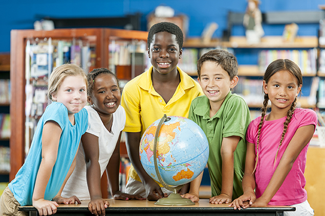 Diverse group of school children standing around a globe