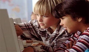 Blonde and Brown haired boys at a computer