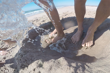 Feet in sand and water